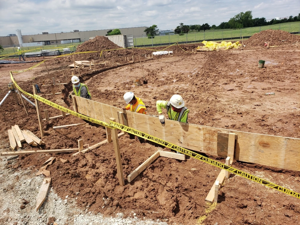 Construction workers building wooden forms at site.